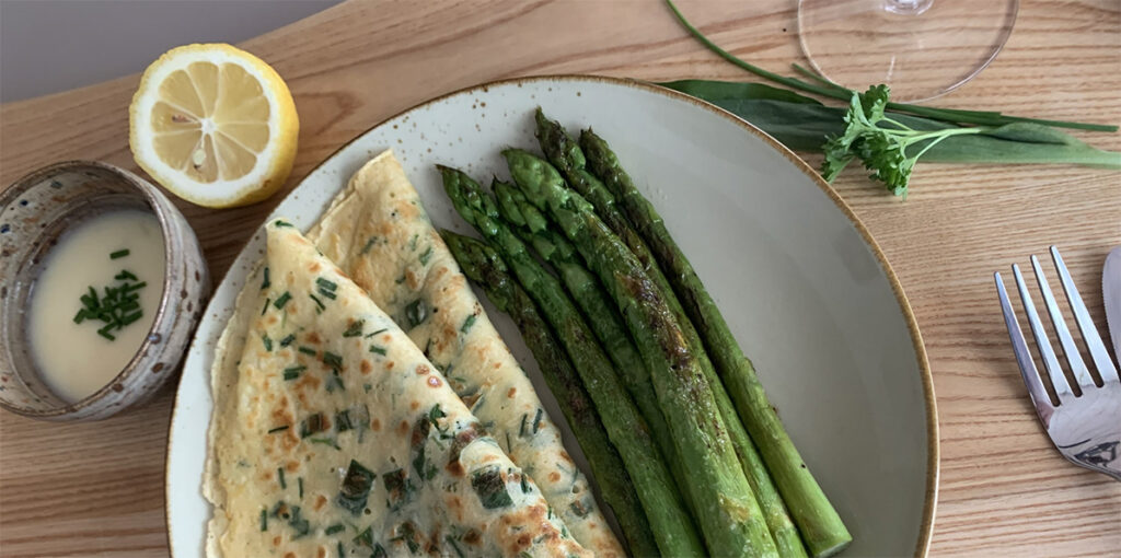 Teller mit grünem Spargel und Kräuterflädle